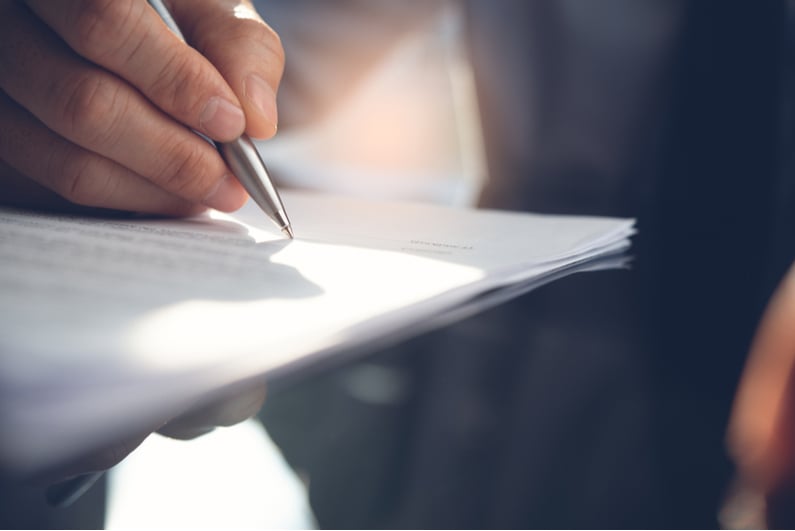 Closeup of person signing a contract